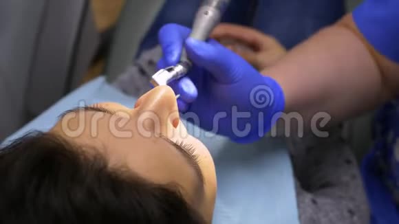 在牙医招待会上漂亮的黑发女孩牙科医生用专业的工具给一个病人做抛光和美白视频的预览图