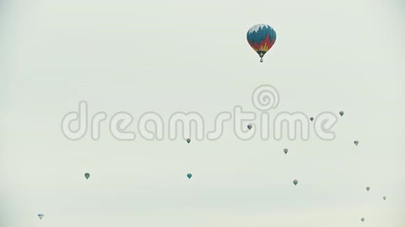在白色天空中飞行的大气球前景上的一个彩色气球视频的预览图