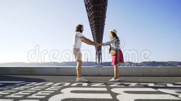 在桥附近的路上跳舞的情侣视频的预览图