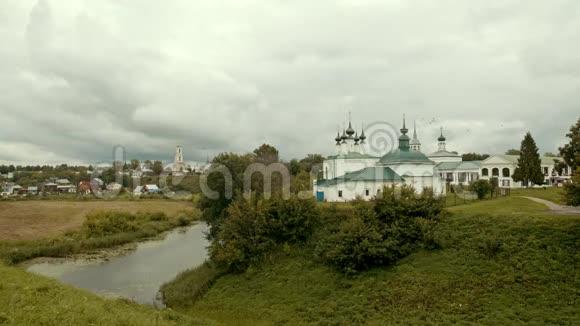 村庄景观一条小溪教堂和鸟儿在天空中飞翔苏兹达尔俄罗斯视频的预览图