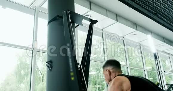 强壮的男性在滑雪板模拟器上工作健身房的交叉健身训练视频的预览图