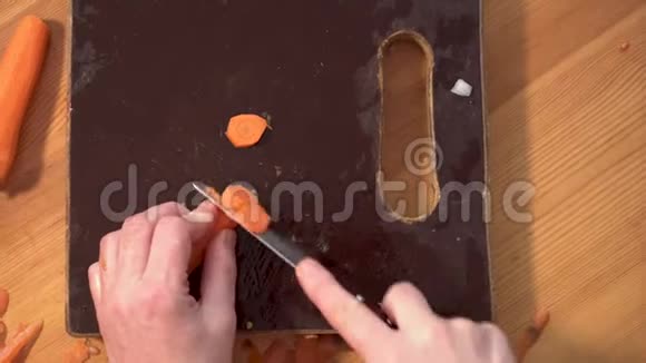手拿刀在木板上切胡萝卜视频的预览图