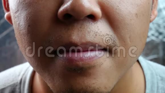 亚洲中年男子在灰色背景下迅速伸出舌头视频的预览图