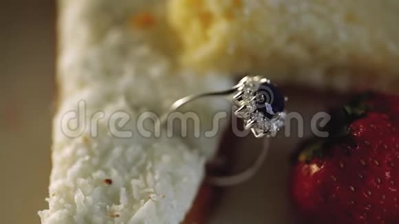 黄金结婚戒指在蛋糕和椰子和草莓钻石珠宝的宏观特写视频的预览图