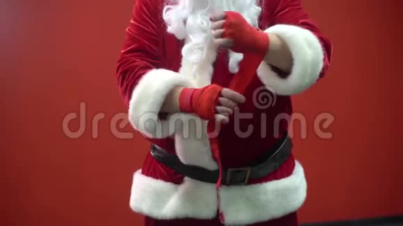 圣诞老人拳击手在红墙的背景下使用红色绷带视频的预览图