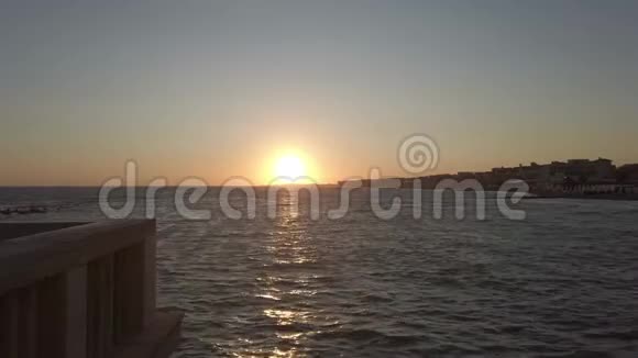 码头的海上日落阳光映照着大海和城市天际线视频的预览图