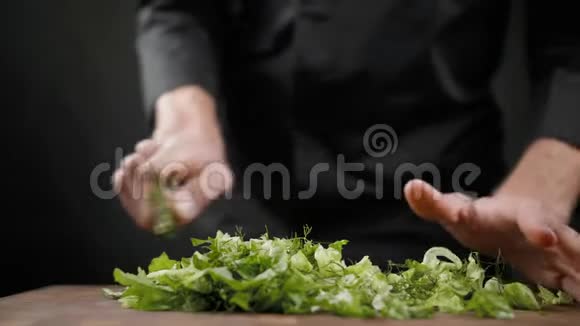 在黑色背景的木桌上为沙拉切下很多绿色生菜视频的预览图
