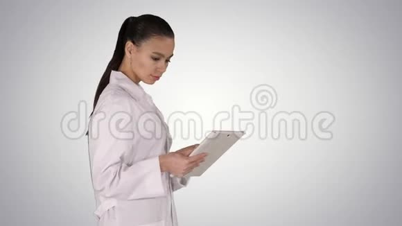 女医生使用平板电脑和步行梯度背景视频的预览图