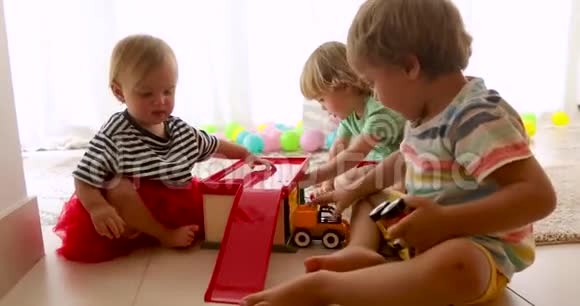 幼儿坐在地板上玩玩具车视频的预览图