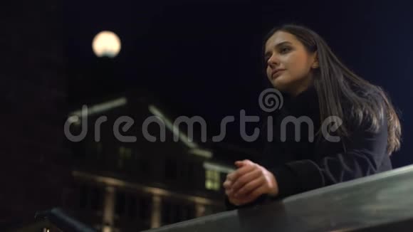 站在夜城街道上思考生活的可怜的年轻女子视频的预览图