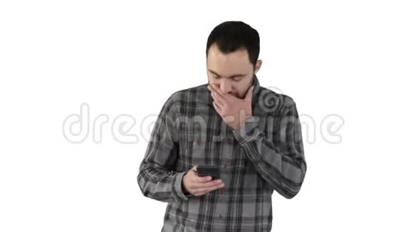 悲伤的年轻人走着看着他的手机他的手在白色的背景上视频的预览图