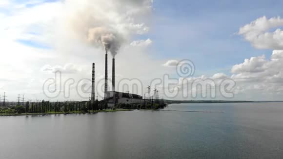 强烈的浓烟来自工业管道与蓝天大自然和一个大湖作对比视频的预览图