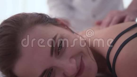 按摩师给年轻女人按摩的快乐脸医生办公室一个女人视频的预览图