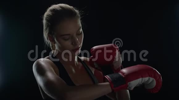 女子拳击手准备在黑暗的健身房运动锻炼女拳击手的肖像视频的预览图