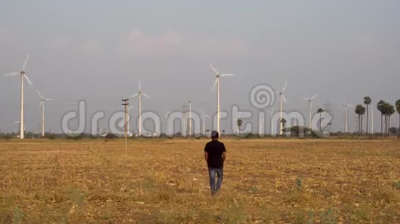 人在风电场为一家风车公司工作走向风电厂进行检查4k视频的预览图