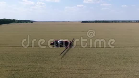 一个自动推进喷雾机的长臂将小麦喷洒在一大片田野上视频的预览图