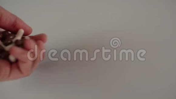 手在一把手中溢出棕色和白色的医疗胶囊视频的预览图