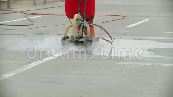 一位老女工用水机场的田地清洗沥青视频的预览图