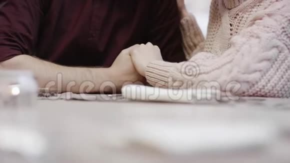 成年男女握着对方手靠桌子接吻视频的预览图