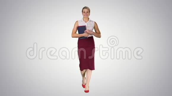 那个女人拿着书在渐变背景下走到相机前视频的预览图