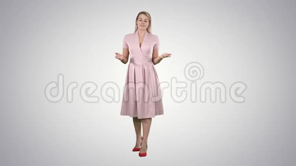 金发女人穿着粉红色的衣服在渐变背景上和镜头交谈视频的预览图