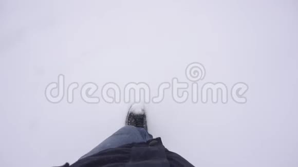 一个人走在雪地里把他的腿从摄像机背景冬天慢动作上移开视频的预览图