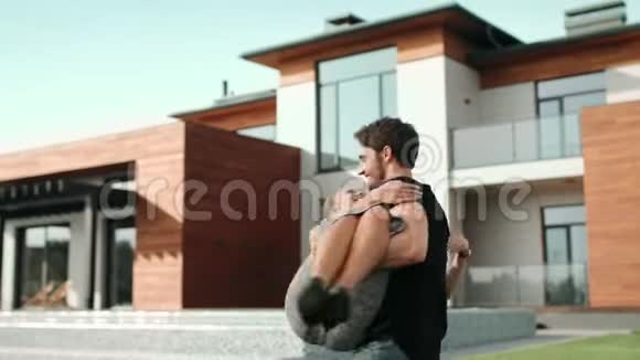 年轻男子抱着女人靠近豪宅富家在新别墅附近拥抱视频的预览图