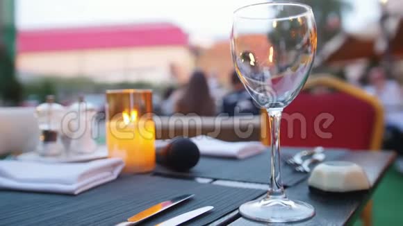 一个空杯子站在桌子上燃烧蜡烛户外餐馆视频的预览图