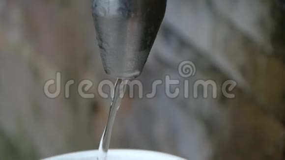 将水从弹簧龙头中注入杯子在缓慢的运动中关闭视频的预览图