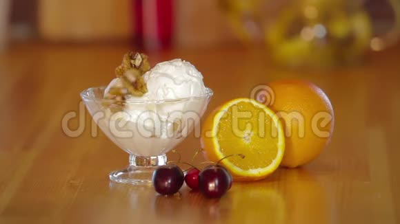夏日甜点玻璃碗里的冰淇淋和核桃橘子和樱桃放在木桌上冰淇淋的制作视频的预览图