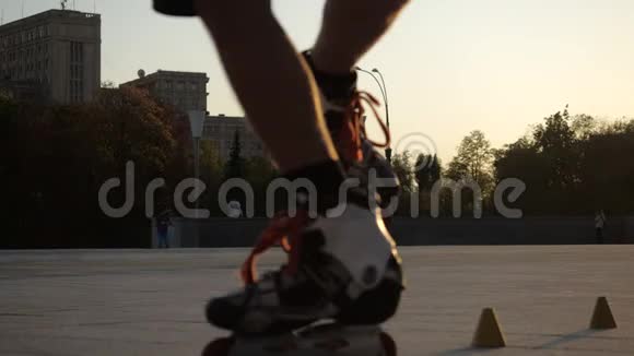 傍晚时分一位年轻的长发男子滑旱冰在城市广场的球果间跳舞自由式回转视频的预览图