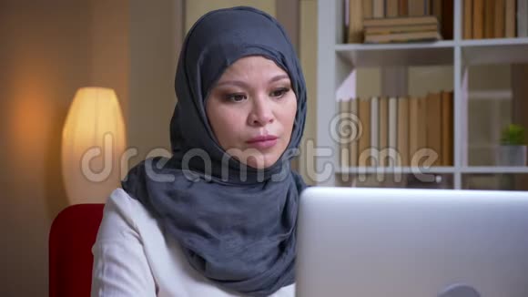 成年穆斯林忙碌的女商人在笔记本电脑上打字在室内工作场所体贴入微的特写镜头视频的预览图