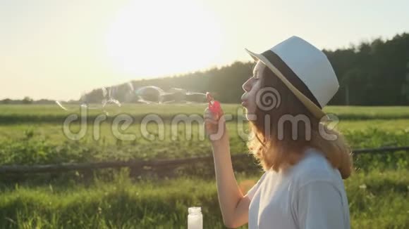 戴帽子吹肥皂泡的漂亮少女视频的预览图