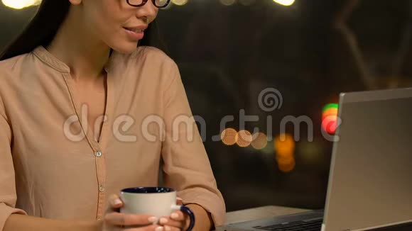 满意的女性自由职业者喝热茶结束成功的工作日视频的预览图