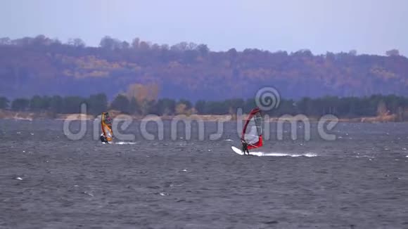 男子运动员从事风帆运动他们在一个大湖上骑木板视频的预览图