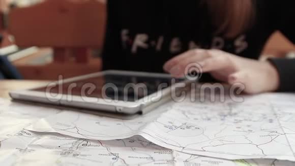 年轻的金发女人在咖啡馆里用平板电脑可爱女孩手持平板电脑的肖像在便携式电脑上浏览视频的预览图