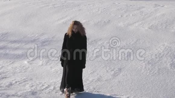 艰难的脚步穿过雪地美丽的年轻女子卷曲的头发直着你视频的预览图