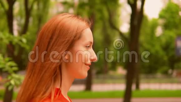侧视着年轻的白种人女性穿着红色衬衫沿着小巷走视频的预览图