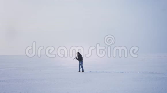 一个白种人音乐家吹喇叭把它在冰冻的湖底上下视频的预览图