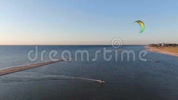 风筝冲浪者带着他的绿色风筝回到海滩乘着风4K视频的预览图