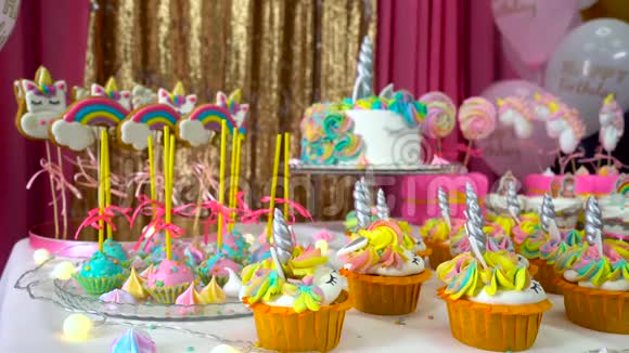 精心装饰孩子们的生日聚会上有美味的纸杯蛋糕五颜六色的棒棒糖和独角兽蛋糕视频的预览图