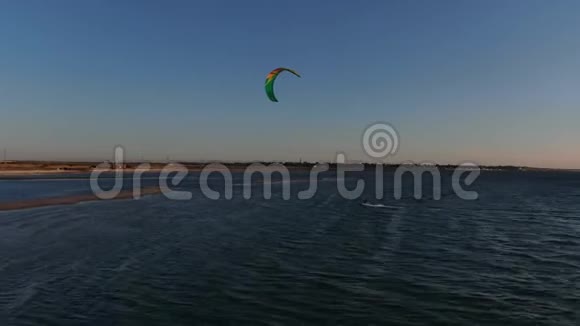 风筝冲浪者停在一个小沙岛日落五彩缤纷的天空4k视频的预览图