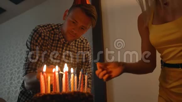 女士和帅哥在美味的生日蛋糕上点燃蜡烛准备参加派对视频的预览图