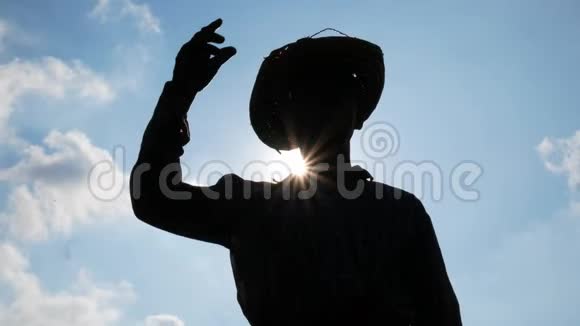 在天空背景下一位亚洲老农下班后摘下帽子擦去脸上的汗水视频的预览图