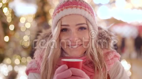 美丽的微笑女人穿着温暖的衣服喝着红茶或咖啡视频的预览图