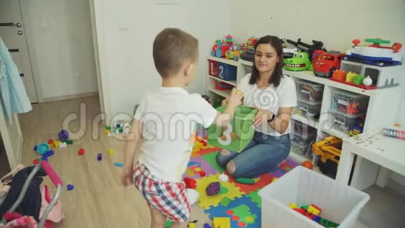 小男孩帮助妈妈打扫玩具室视频的预览图