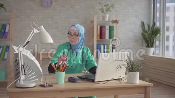 现代诊所工作场所戴头巾的穆斯林妇女视频的预览图