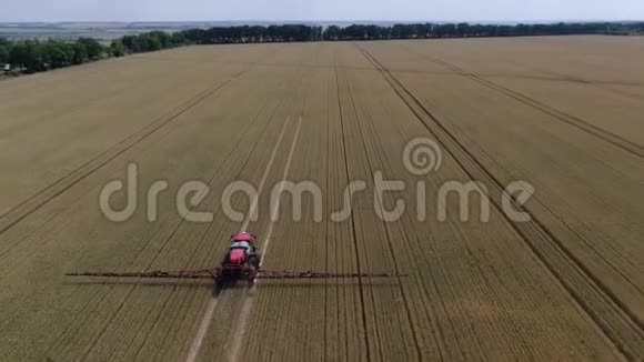 大片麦田被树木包围一台机器正在给植物浇水视频的预览图
