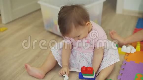 可爱的小女孩玩积木和玩具熊视频的预览图