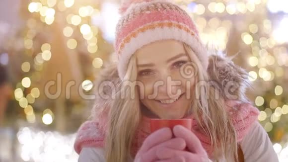 美丽的微笑女人穿着温暖的衣服喝着红茶或咖啡视频的预览图